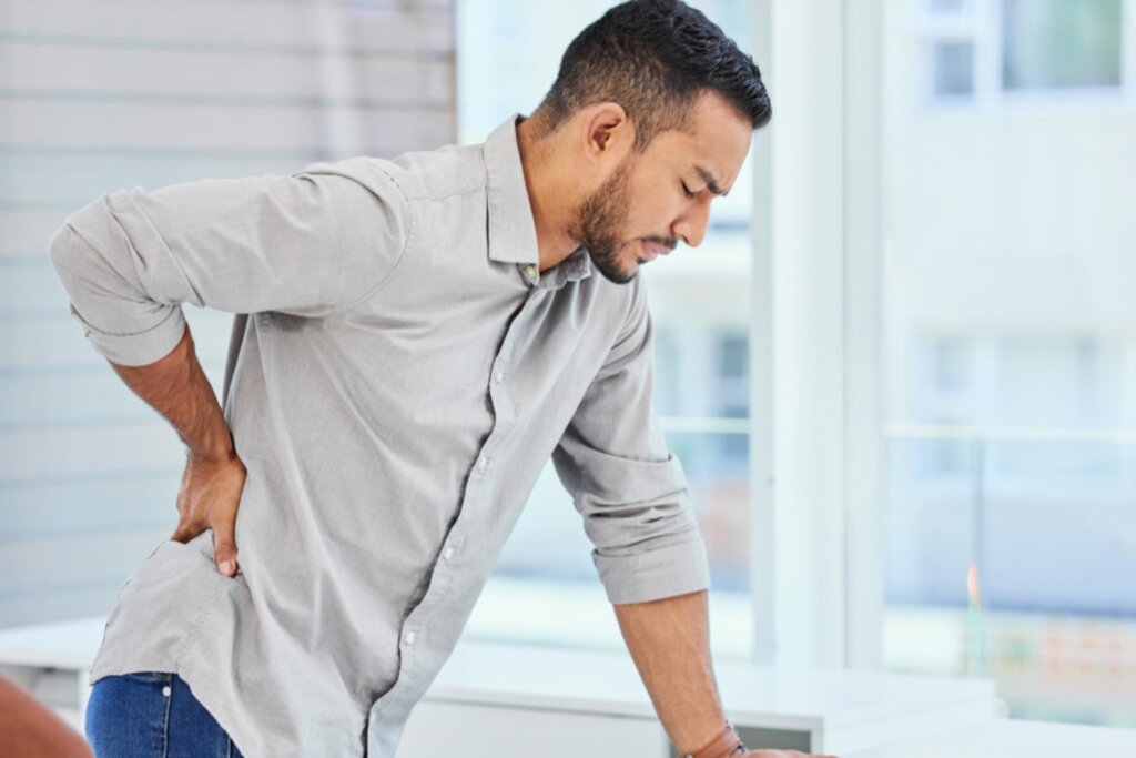 Person suffering from slipped disc in lower back – nerve compression and spinal pain treatment at IBAP Clinics Hyderabad